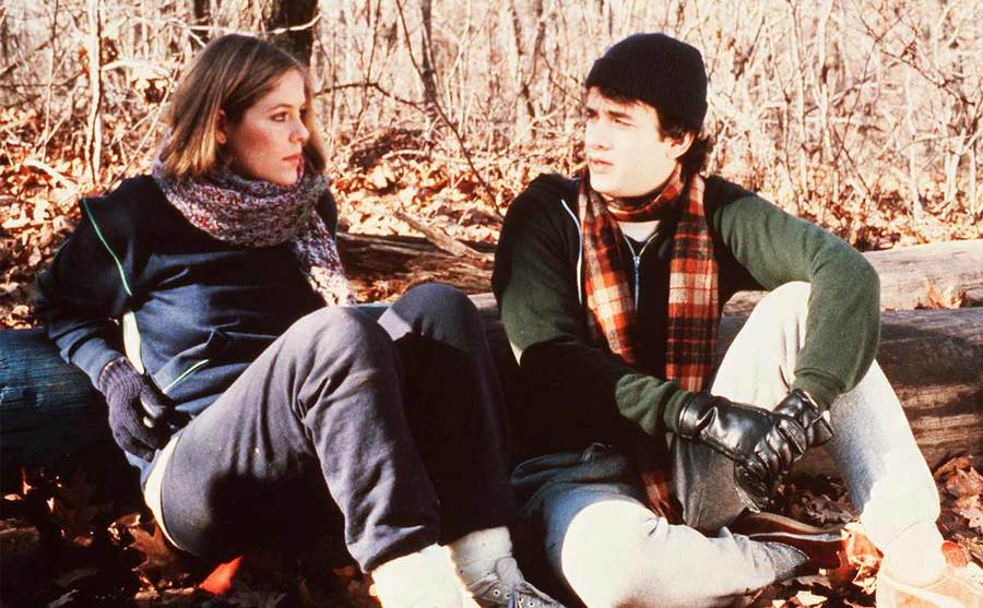 Elizabeth Kemp and Tom Hanks sitting near a log in the woods in the film He Knows You’re Alone 