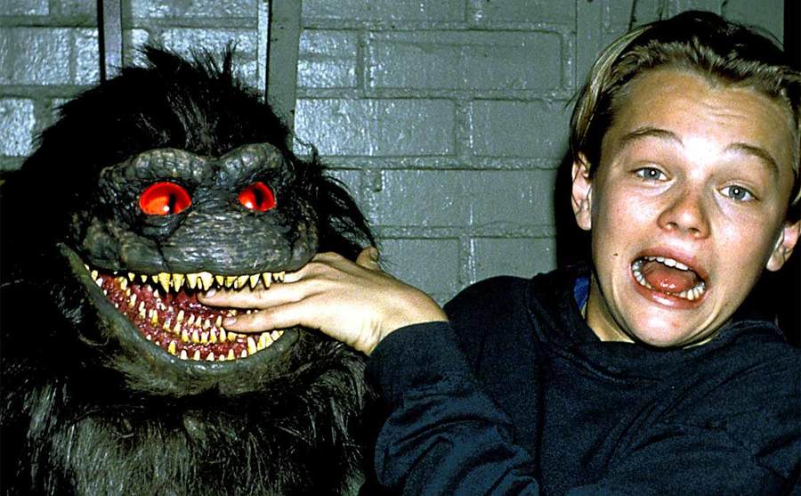Leonardo DiCaprio with his fingers in the puppet’s mouth who played a critter in Critters 3