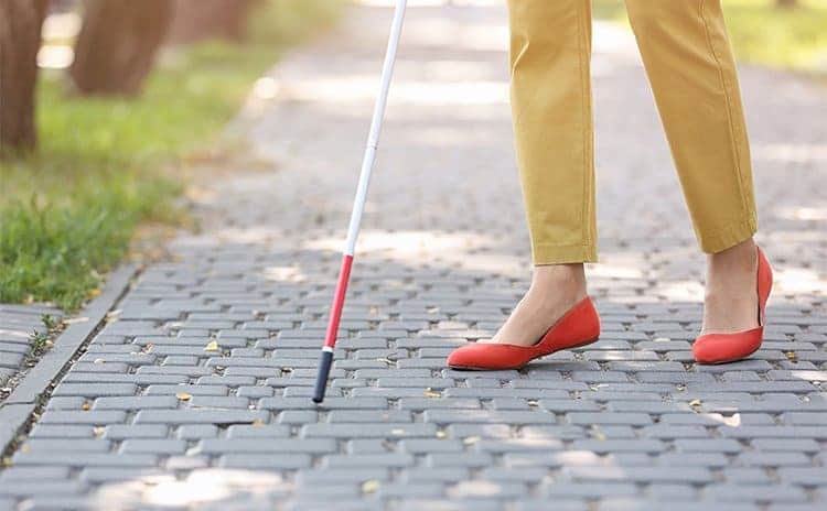 A blind woman walking in the street 