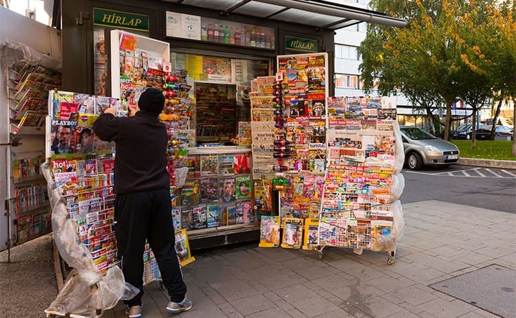 A person opening up a newsstand 