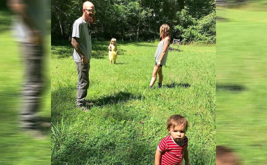 Luke and Rachel with the kids playing in a large grassy field 