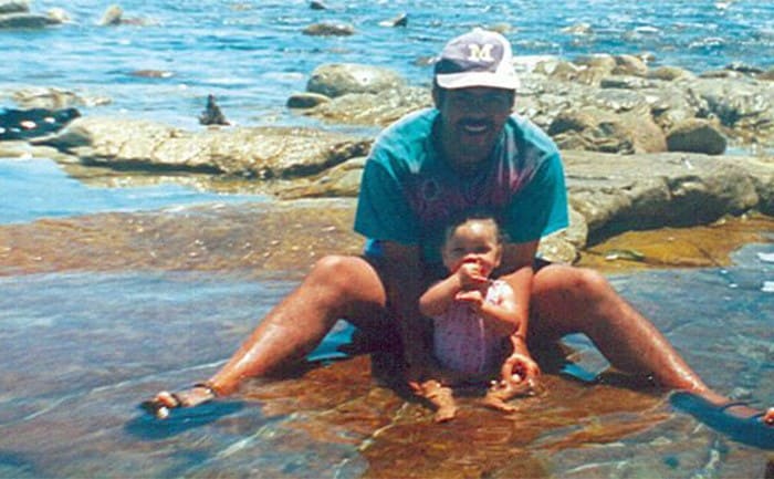 Michael and Miché as babysitting on the edge of a body of water 
