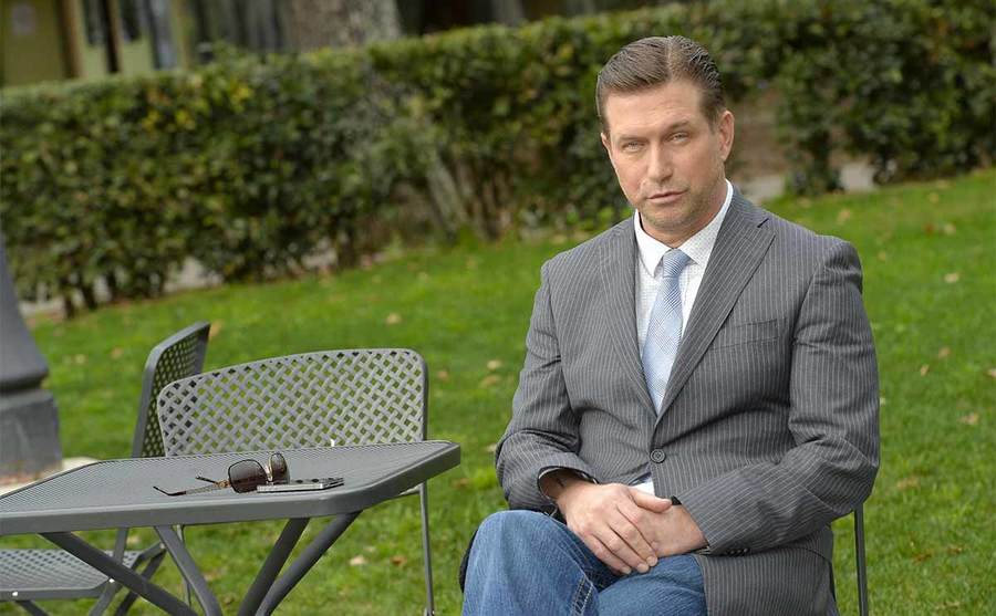 Stephen Baldwin sitting at an outdoor table with his phone and sunglasses sitting on it 