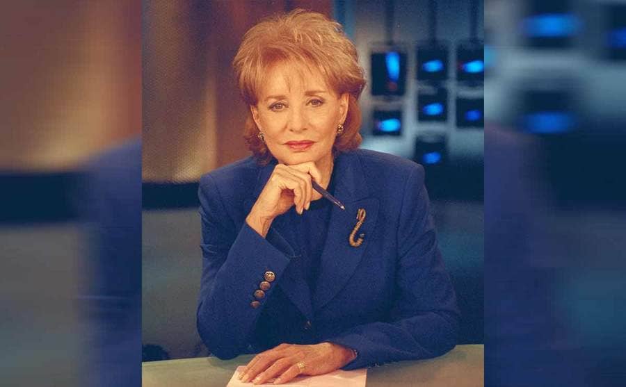 Barbara Walters sitting behind a news desk on the set of 20 / 20