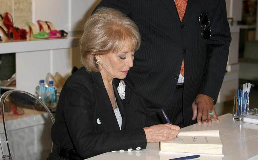 Barbara Walters signing her book at a book signing 