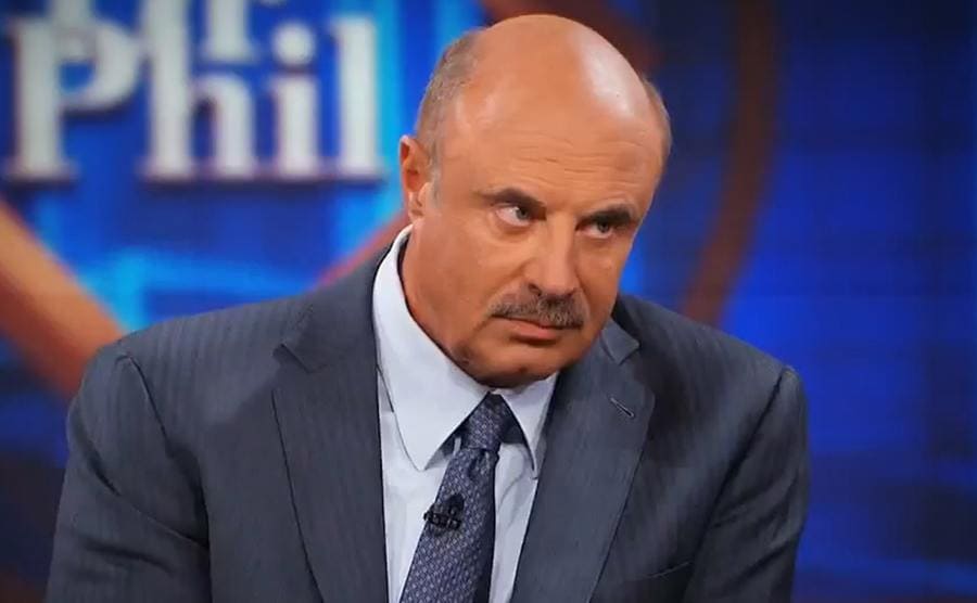Dr. Phil on the set of his show looking down on someone who is out of the photograph 