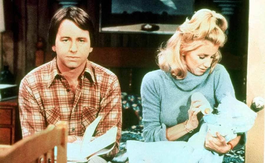 John Ritter and Suzanne Somers holding a baby in a scene from Three’s Company 