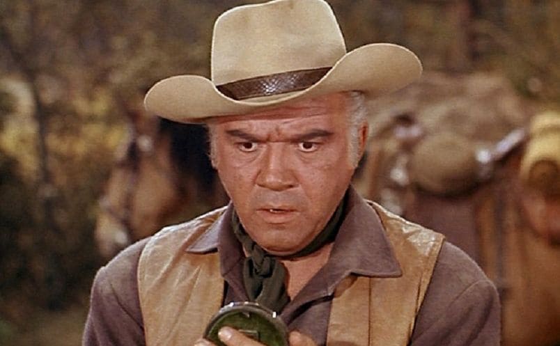 Lorne Greene looking at something circular in his hands with a shocked look on his face 