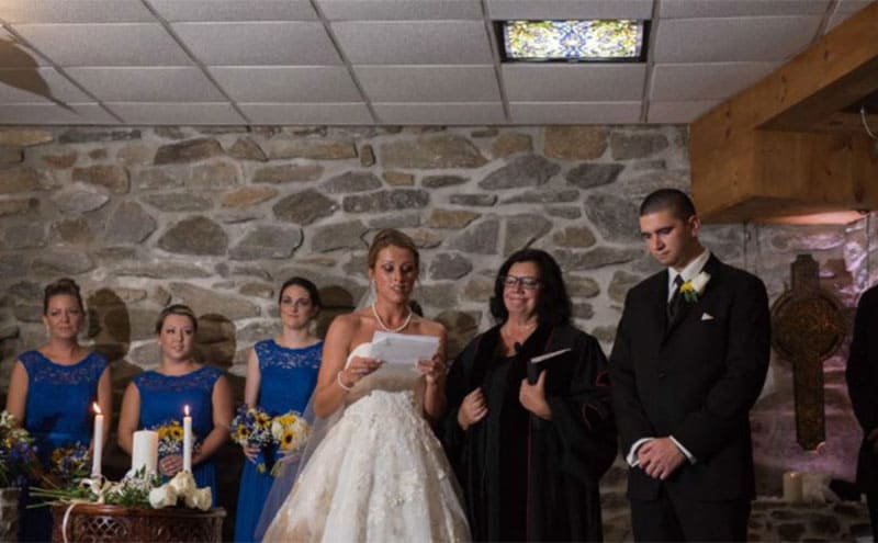 Katie reading her vows at the altar on their wedding day 