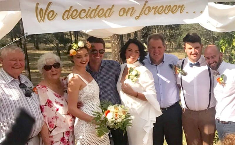 Miranda Kerr with her family posing under a banner on her brother's wedding day