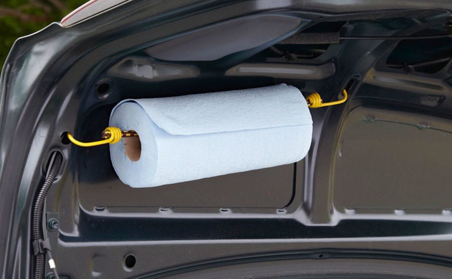 A roll of paper towels attached to the inside of a trunk door 