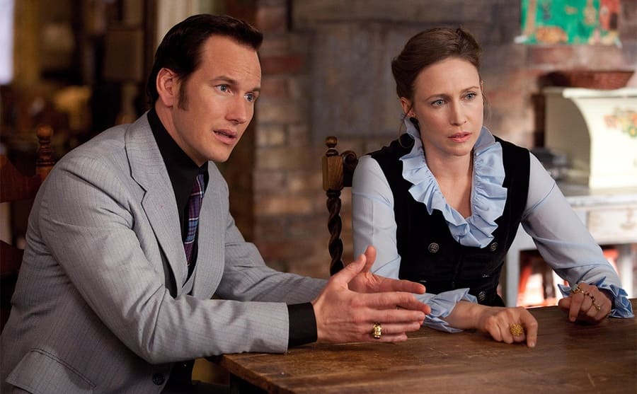 Patrick Wilson and Vera Farmiga sitting at the kitchen table in a scene from The Conjuring 
