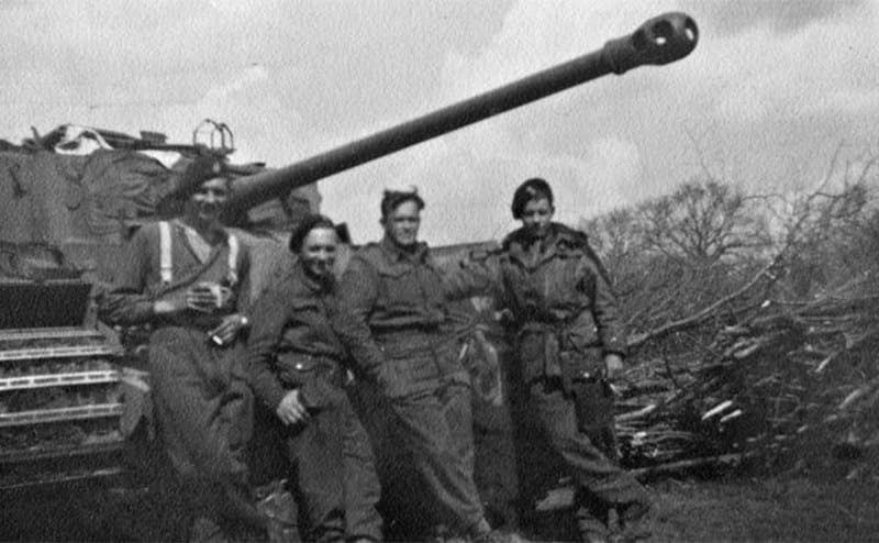 Cyril Mowforth and other soldiers standing by a tank 