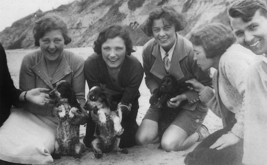 Bessie on the beach with her friends and puppies circa the 1930s