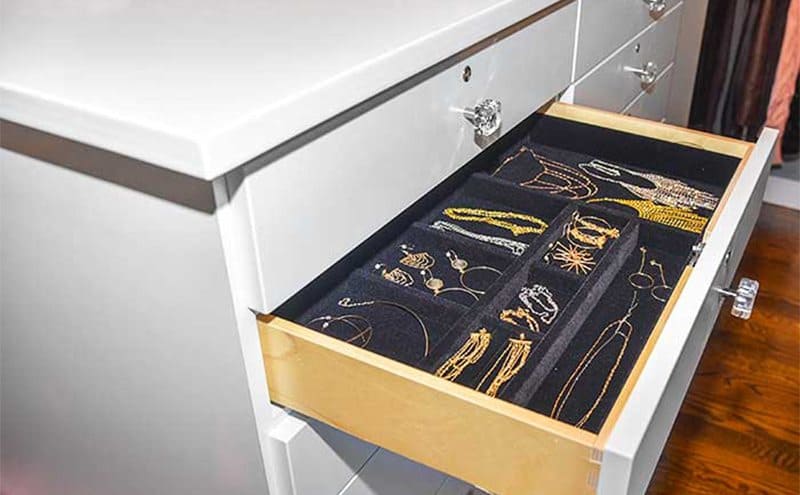 An opened dresser filled with jewelry with locks on every drawer 