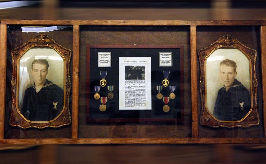 Photographs of the twins next to their framed medals and newspaper article 