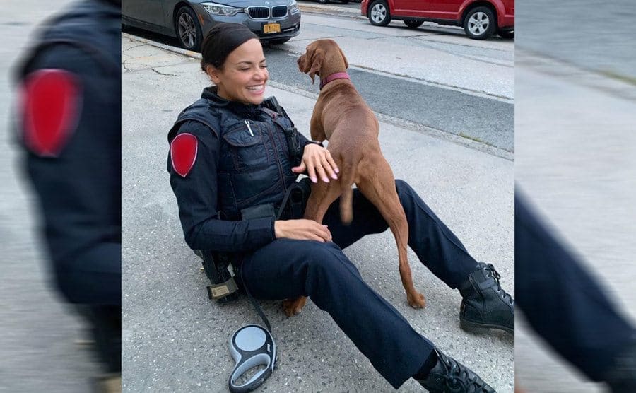 Samantha Sepulveda in a police uniform playing with a dog