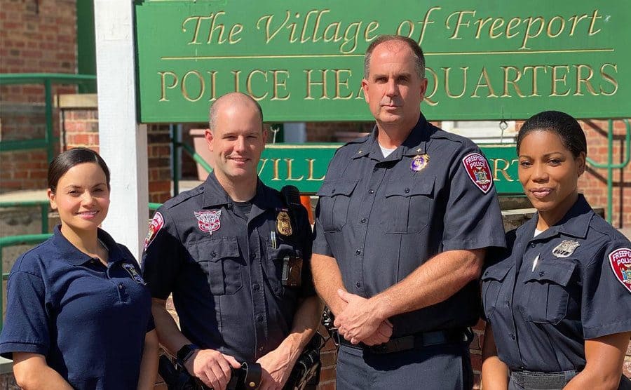Samantha Sepulveda and three other cops standing in front of the “The Village of Freeport” sign