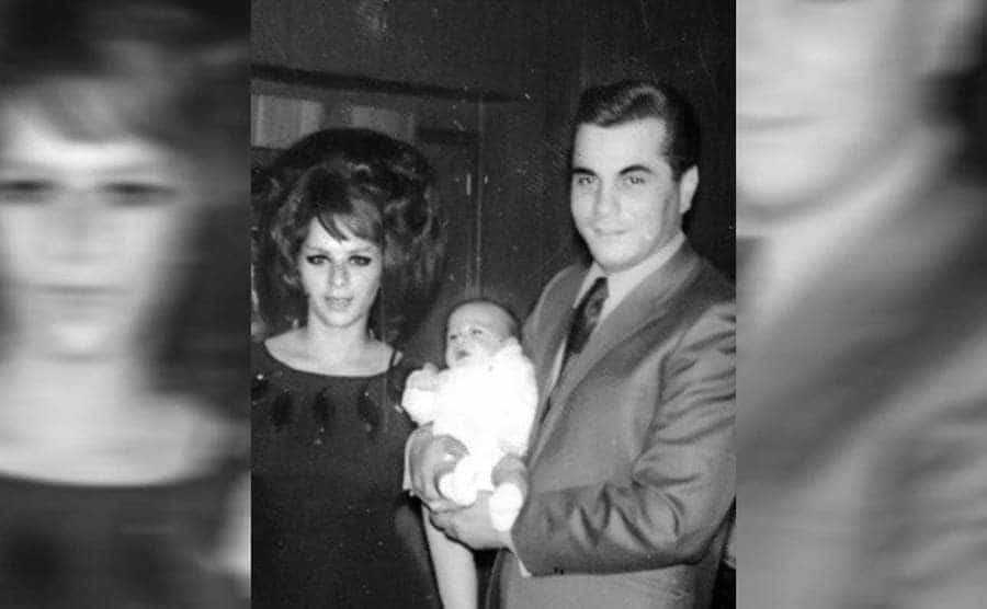 John Gotti holding his baby son standing next to his wife