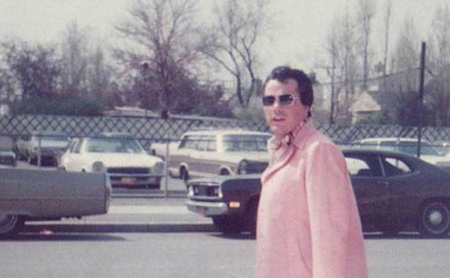 John Gotti wearing a pink suit and sunglasses.