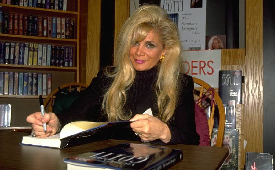 Victoria in her office signing a book