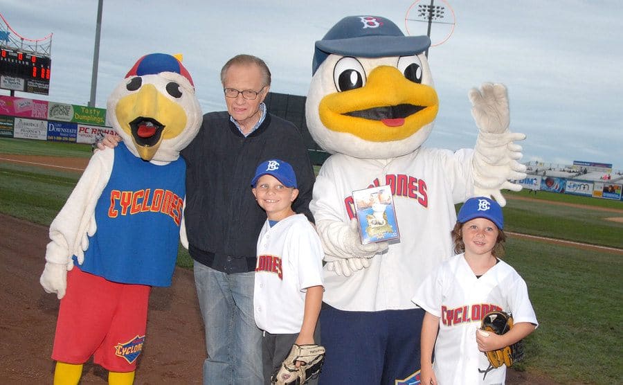 Larry King with his sons on the baseball field with the Cyclones mascots 
