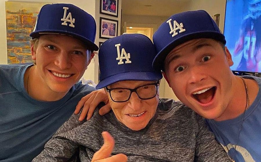 Larry King with his sons wearing LA baseball hats 