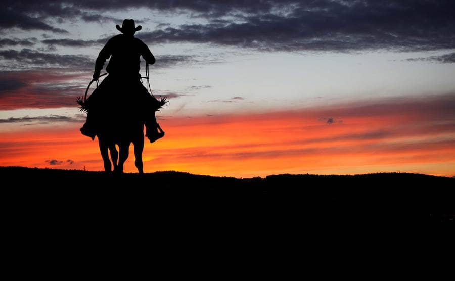 A man riding a horse at sunrise