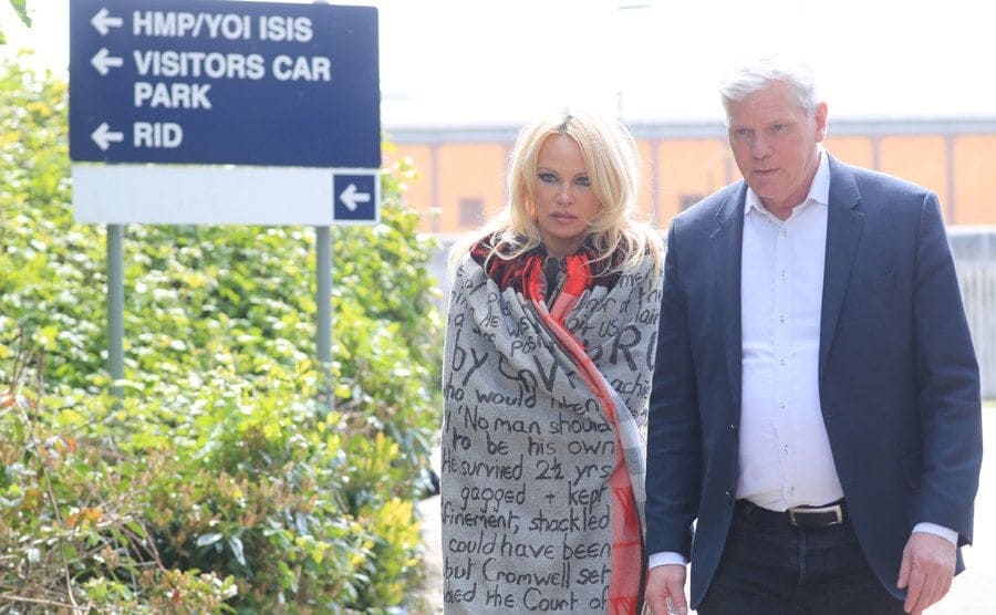 Pamela Anderson y Kristinn Hrafnsson saliendo de la cárcel tras visitar a Julian Assange.