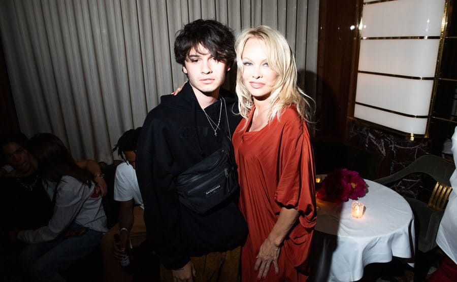 Dylan Lee and Pamela Anderson posing at a party together 
