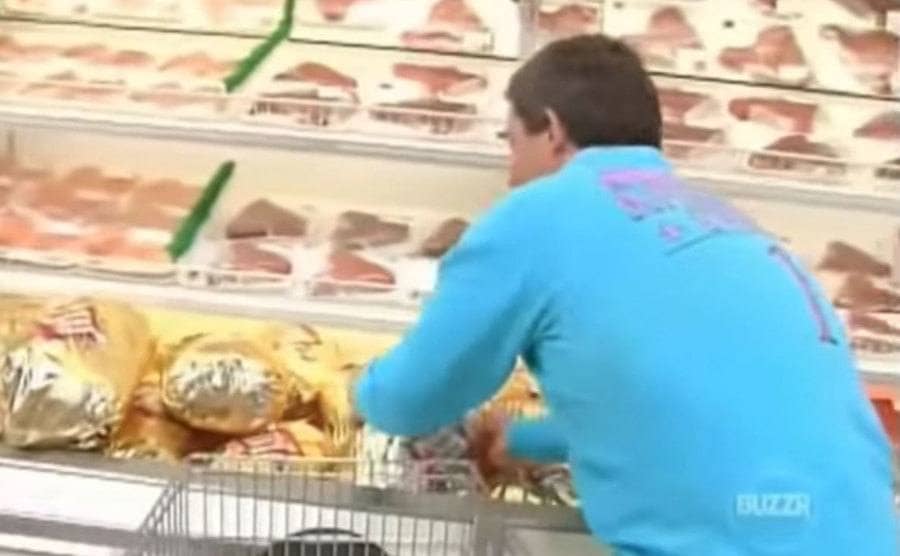 A Supermarket Sweep contestant grabbing “cold” meat from the freezers and throwing it into his cart. 
