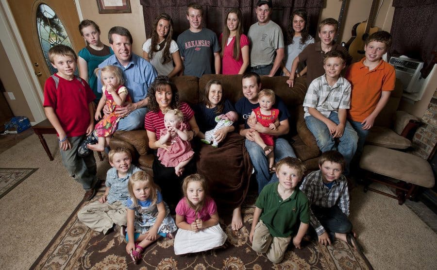 The whole Duggar Family at home sitting on the couch, they never put their arms around one and another in photos. 