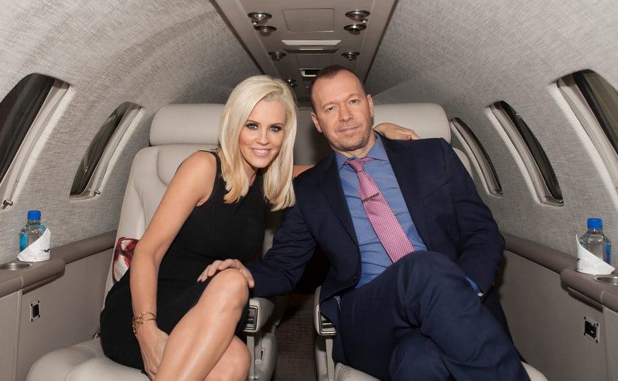 Jenny McCarthy y Donnie Wahlberg sentados en un jet privado