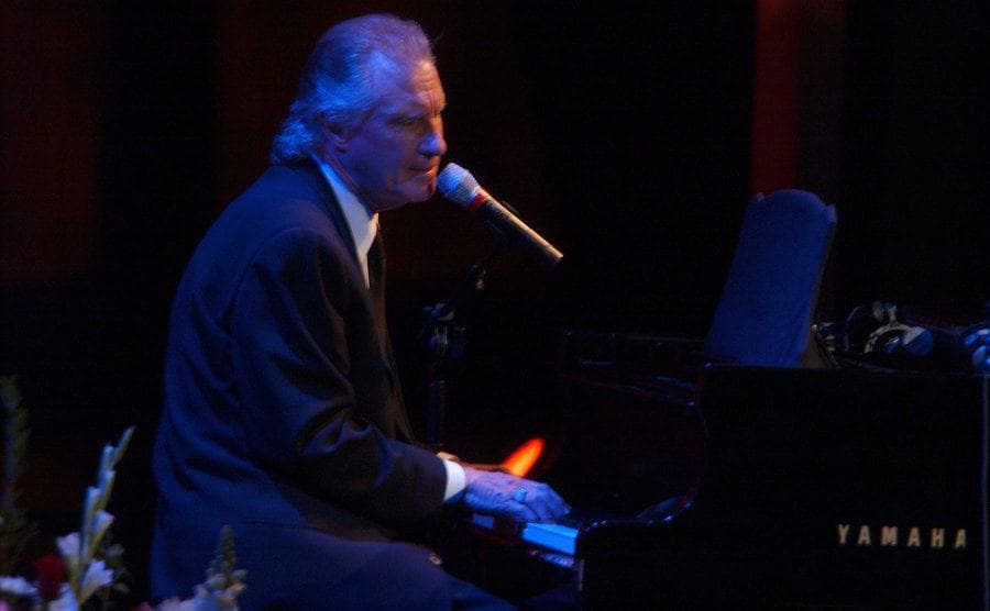 Bill Madley performing on stage while playing the piano. 