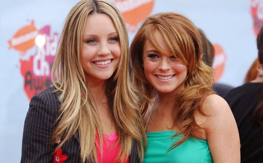 Amanda Bynes and Lindsay Lohan posing on the red carpet back in 2004