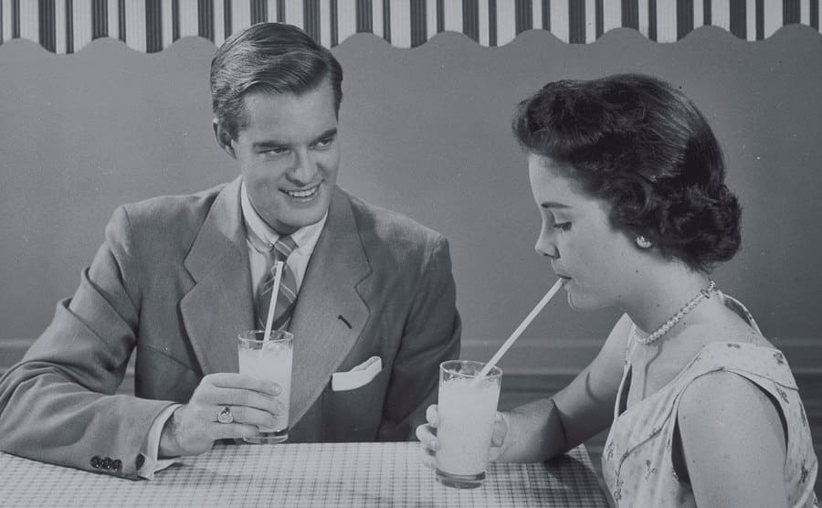 A couple having a drink while on a date during the 1950s.
