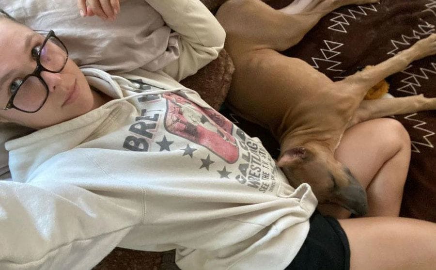 Ronda cuddling with her dog on the couch 
