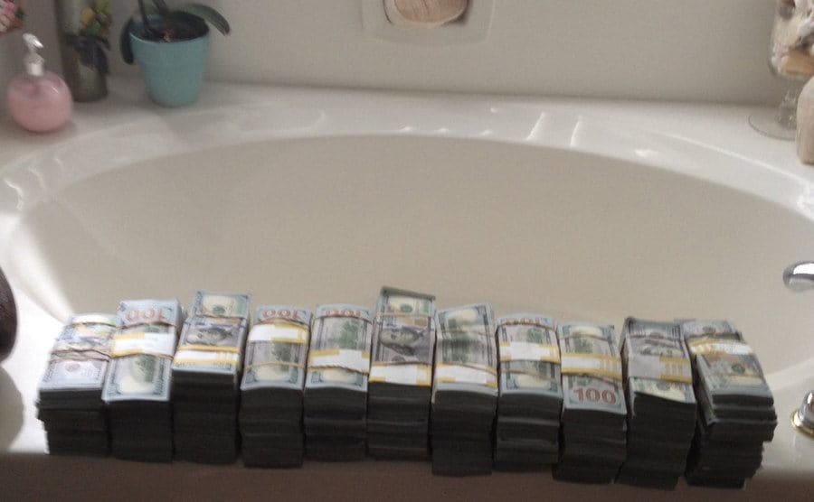 Stacks of hundred-dollar bills found in the safe place on the edge of a tub. 