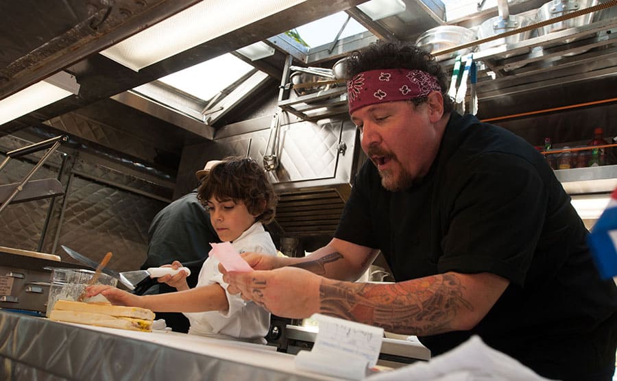 Jon Favreau cooking with child actor Emjay Anthony in a scene from Chef