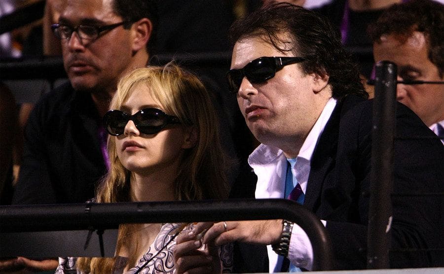 Actress Britney Murphy and husband Simon Monjack watch as Roger Federer of Switzerland plays a match against Andy Roddick during day eleven of the Sony Ericsson Open