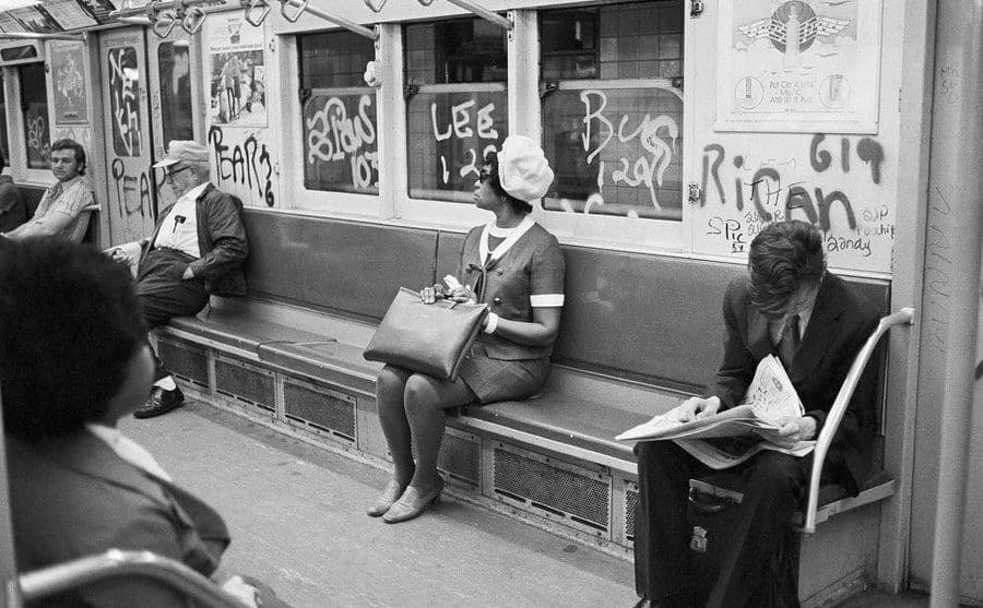 A woman sitting on a New York subway train circa 1970.