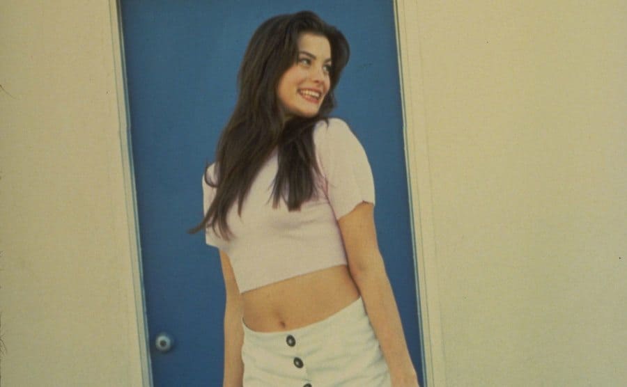 A teenage Liv Tyler modeling for a photoshoot and a teen. 