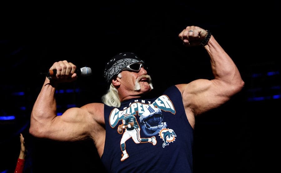 Hulk Hogan flexing holding a microphone 