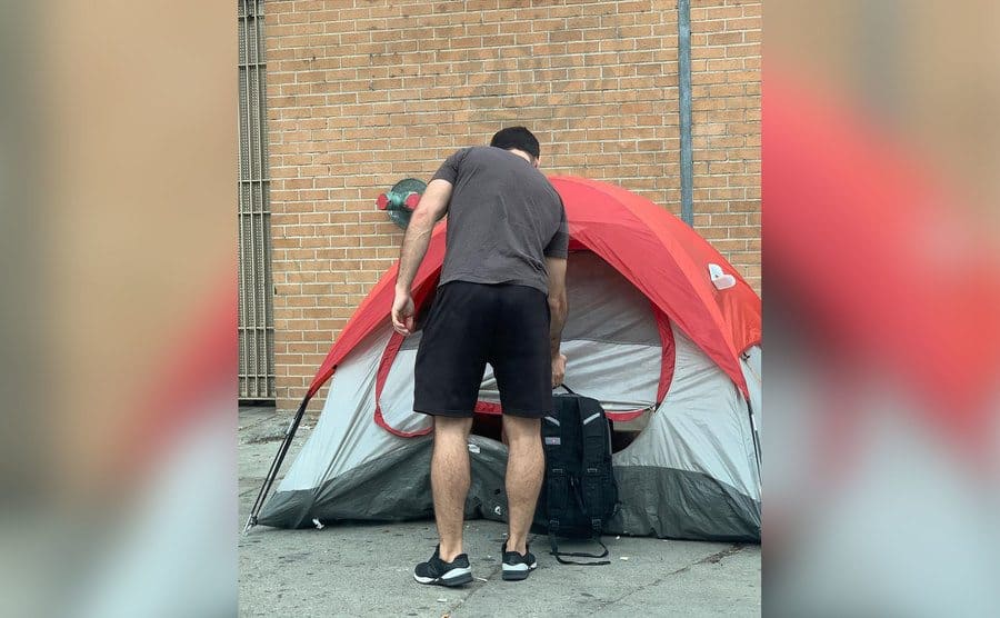 John Suazo is leaving a backpack in front of a homeless person's tent. 