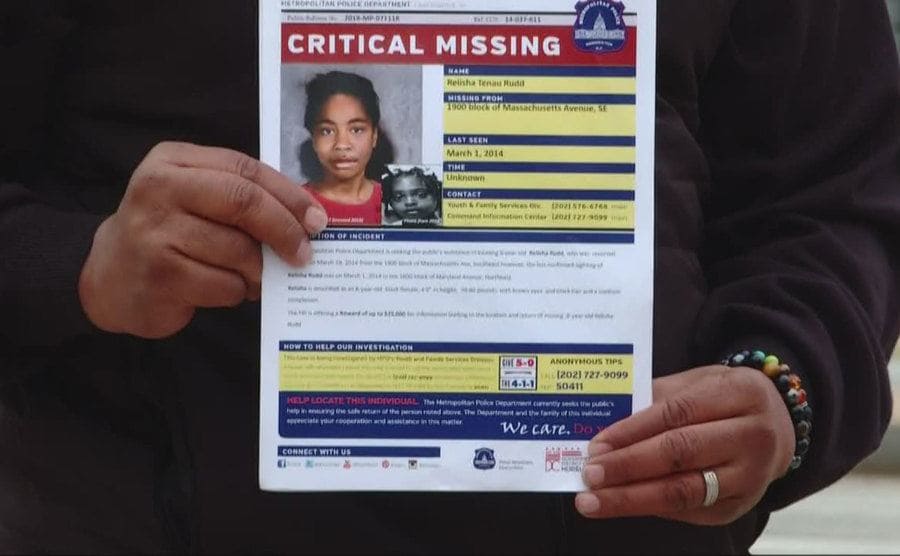 Cropped photo of someone holding up a missing person flyer for Relisha Rudd. 