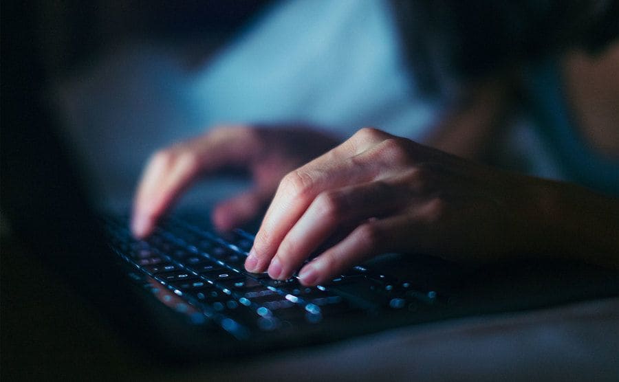 Close-up shot of female hands typing on a computer keyboard. 