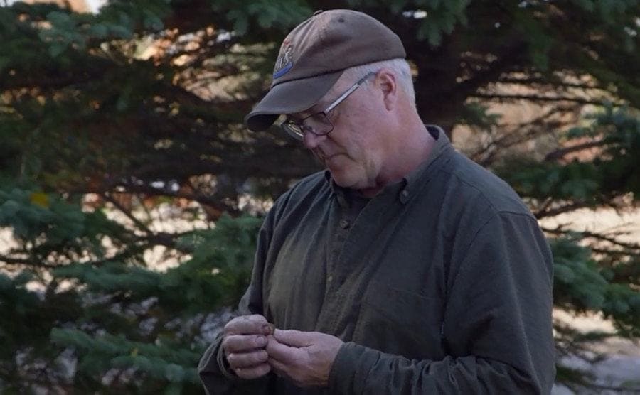 Laird Niven examining an artifact found on the island.