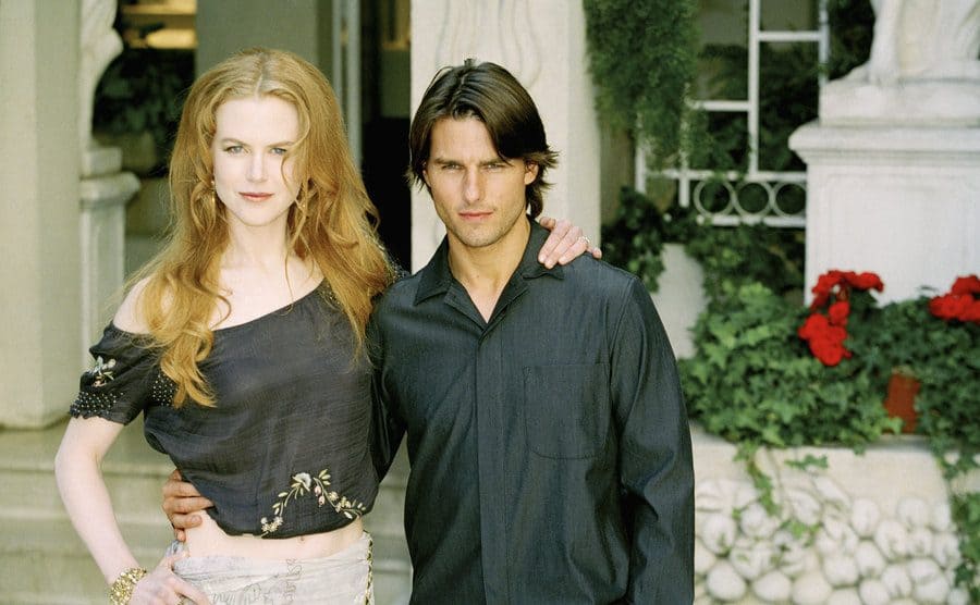 Nicole Kidman and Tom Cruise posing in front of a hotel garden to promote their film 