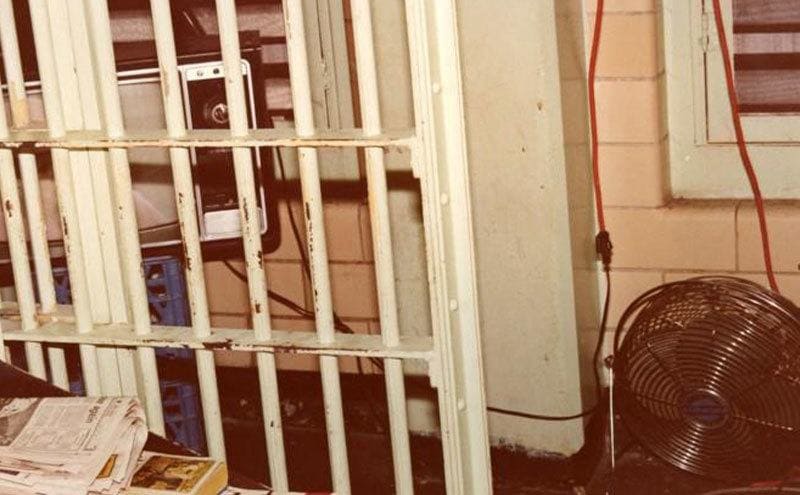 The inside of Charles Harrelson’s jail cell, with a tv, some books and a few newspapers.