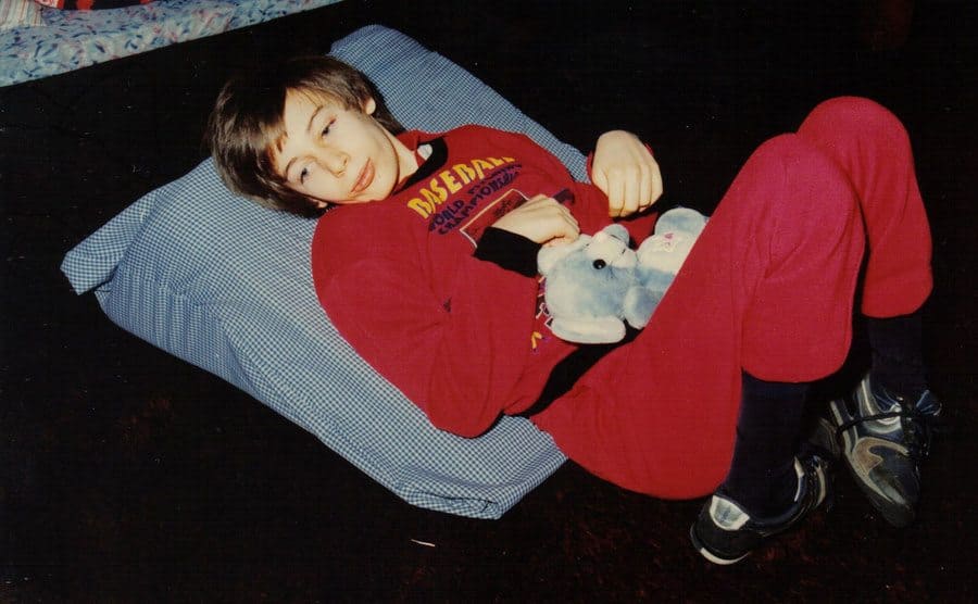 Martin is dressed in pajamas as he rests on a pillow on the floor. 